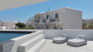 A modern building with a pool and outdoor seating.