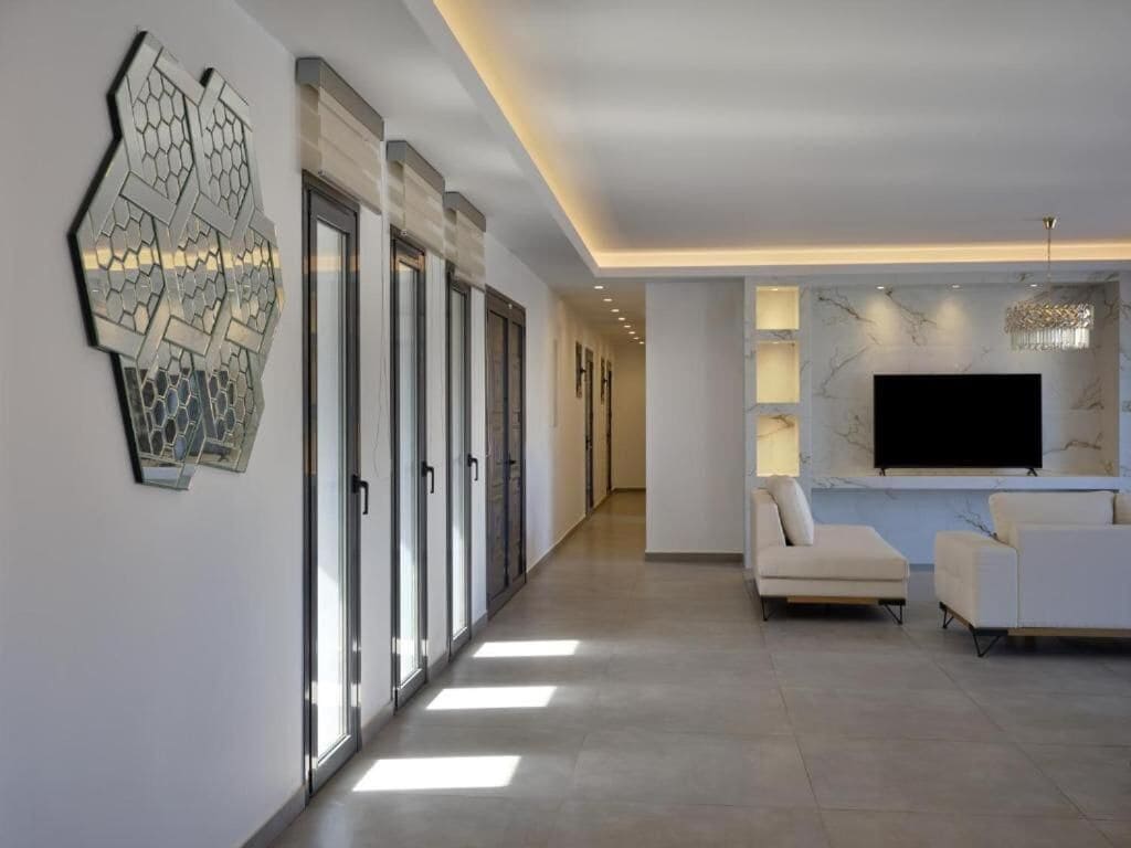 Una sala moderna con un televisor de pantalla plana, dos sofás y un elemento decorativo en la pared.