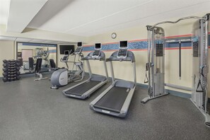 A gym with treadmills, elliptical machines, and weightlifting equipment.