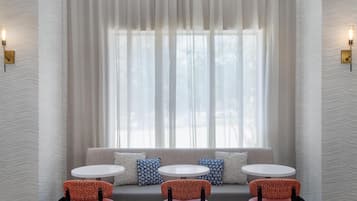 A modern interior with a seating area featuring a sofa and three round tables.