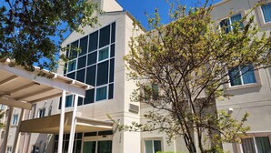 A modern building with large windows and a covered entrance area.