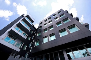 A multi-story building with a modern architectural design, featuring large windows and a flat facade.