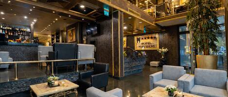 A hotel lobby with a reception desk, seating area, and a sign reading 'HOTEL PRESIDENT.'