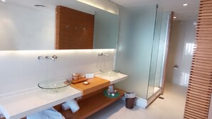 A modern bathroom with a large mirror, two sinks, and a glass shower enclosure. - CasaCalma Hotel (Buenos Aires)
