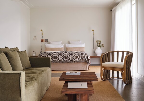 A bedroom with a bed, a sofa, a chair, a wooden coffee table, and bedside lamps. - Lancemore Milawa (Milawa)