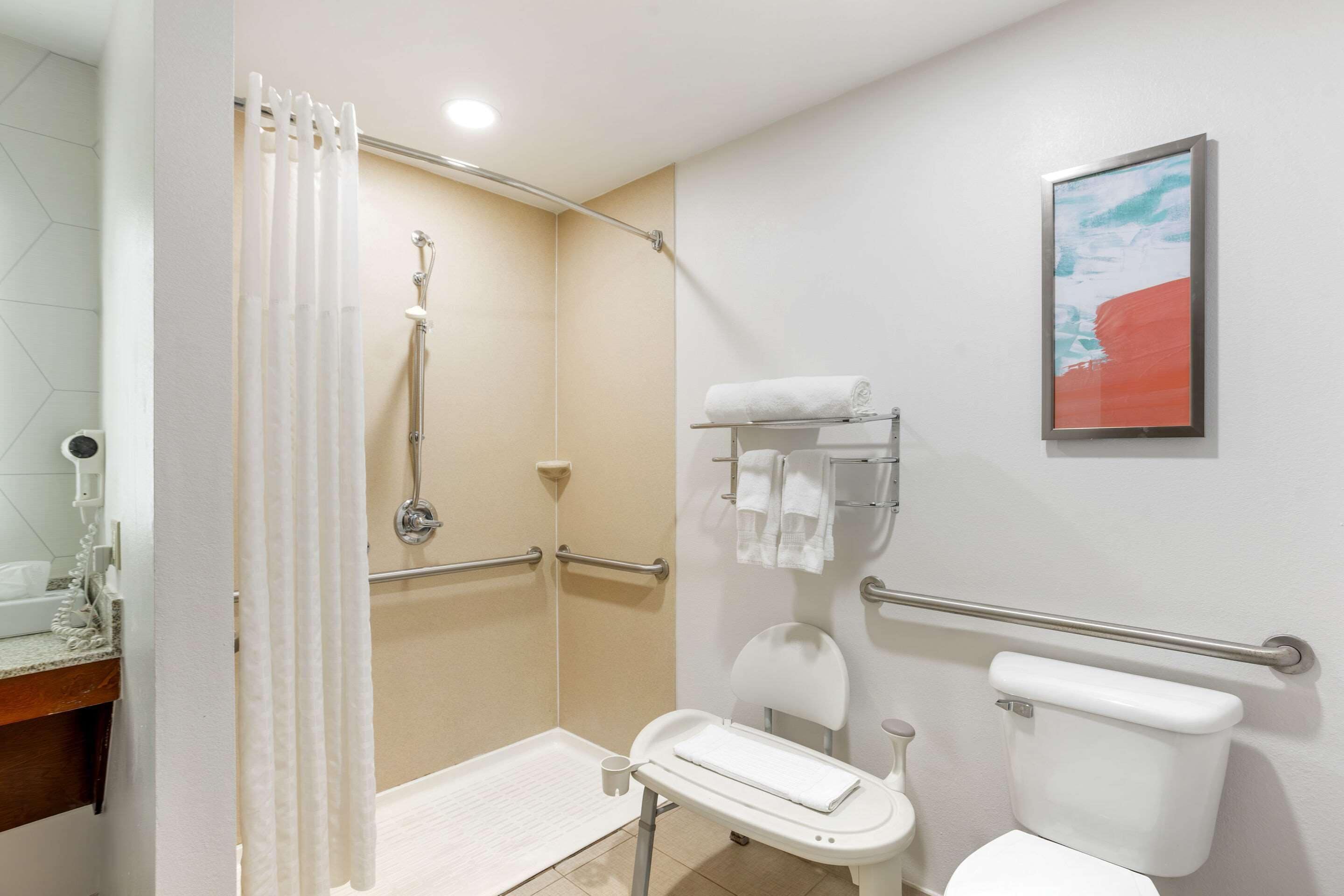 A bathroom with a shower, toilet, and sink.