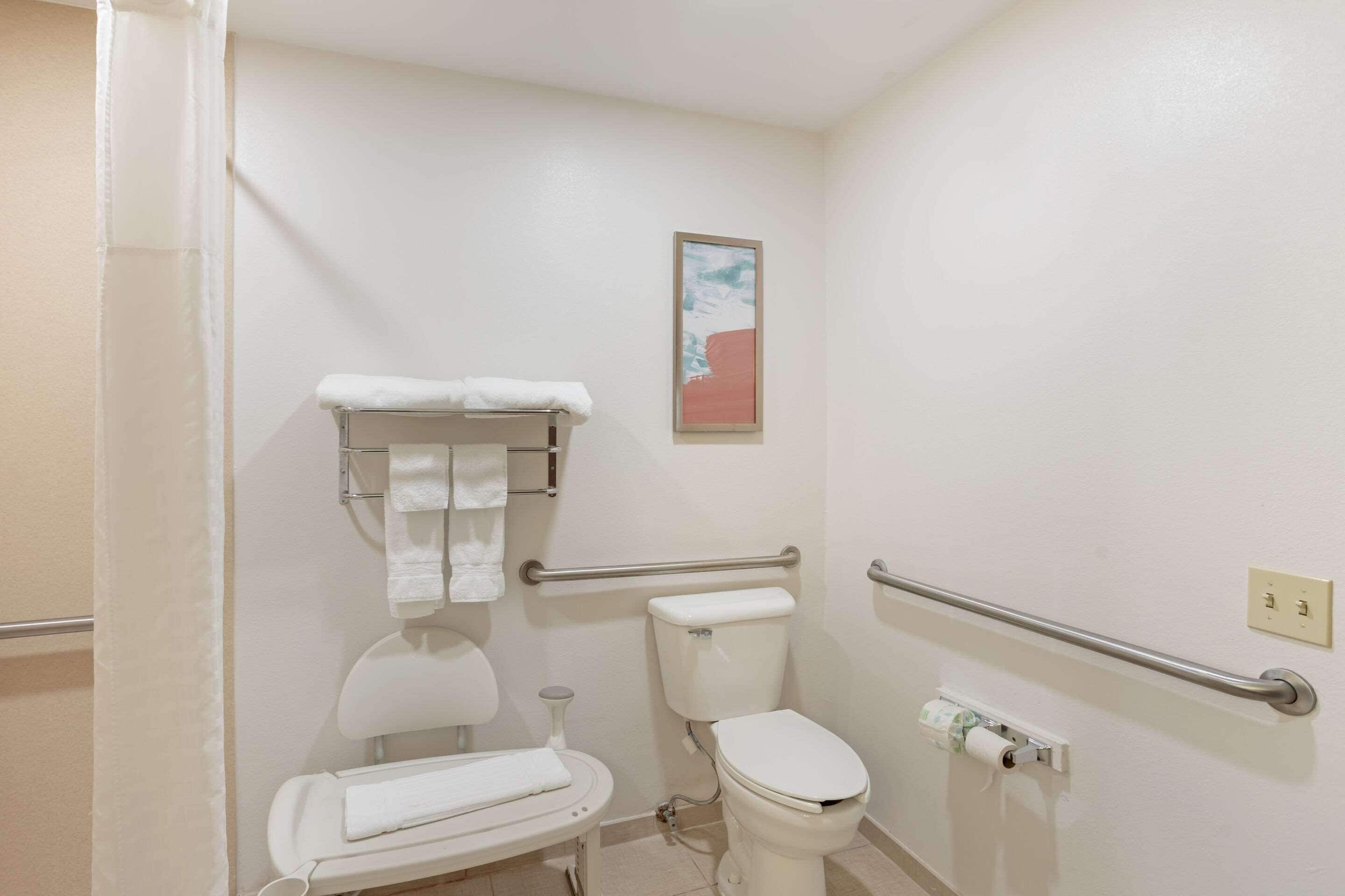 A bathroom with a toilet, a sink, a shower, and a towel rack.