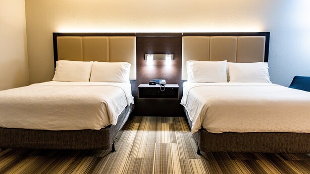 A hotel room with two beds, a nightstand, and a wall-mounted lamp. - Holiday Inn Express Columbus-Dublin by IHG (Dublin)