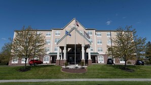 A large building with a central entrance, columns, and a flagpole. - Country Inn & Suites by Radisson, Harrisburg - Hershey West, PA (Harrisburg)
