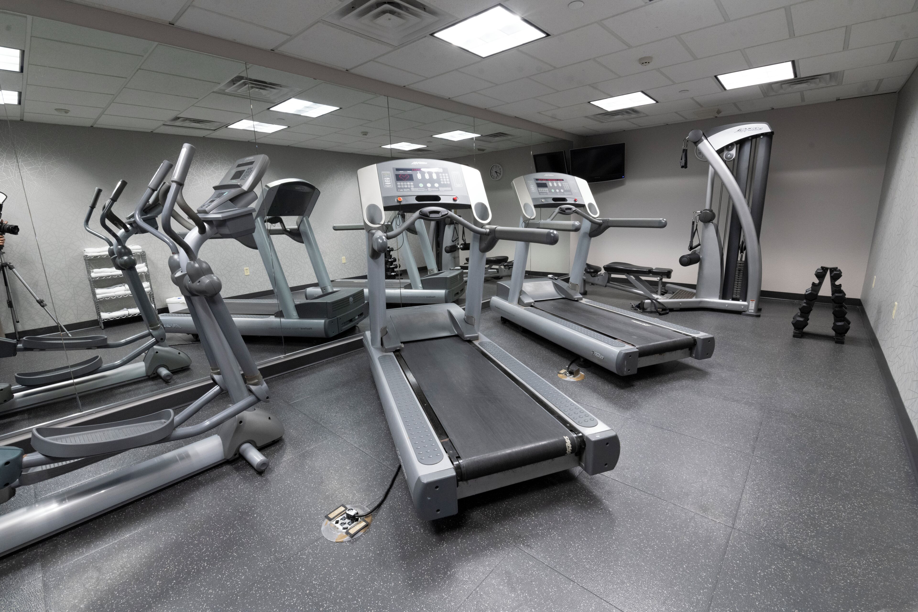 A gym with multiple treadmills, ellipticals, and a stationary bike.