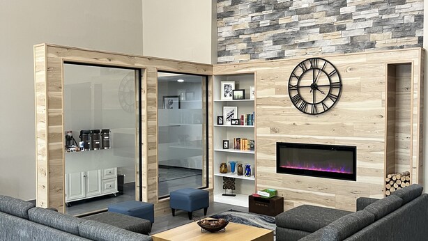 A modern living room with grey sofas, a wooden coffee table, and a stone-patterned wall. - Country Inn & Suites by Radisson, Harrisburg - Hershey West, PA (Harrisburg)