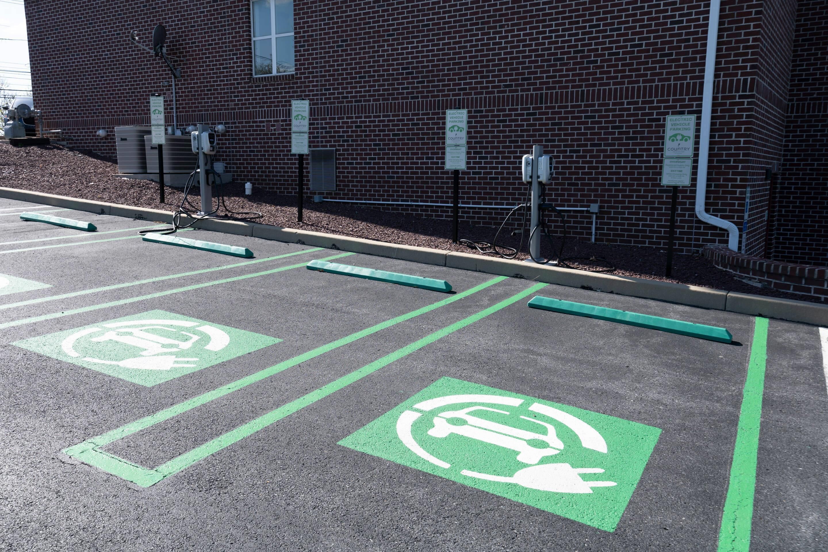 A parking area with electric vehicle charging stations and designated parking spaces.