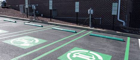 A parking area with electric vehicle charging stations and designated parking spaces.