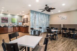 A restaurant with a counter, seating area, and a ceiling fan. - Sleep Inn and Suites at Kennesaw State University (Kennesaw)