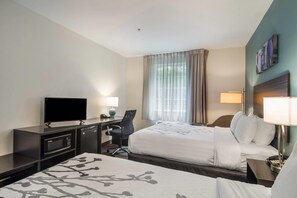 A hotel room with two beds, a desk with a flat-screen TV, a chair, and a desk lamp. - Sleep Inn and Suites at Kennesaw State University (Kennesaw)
