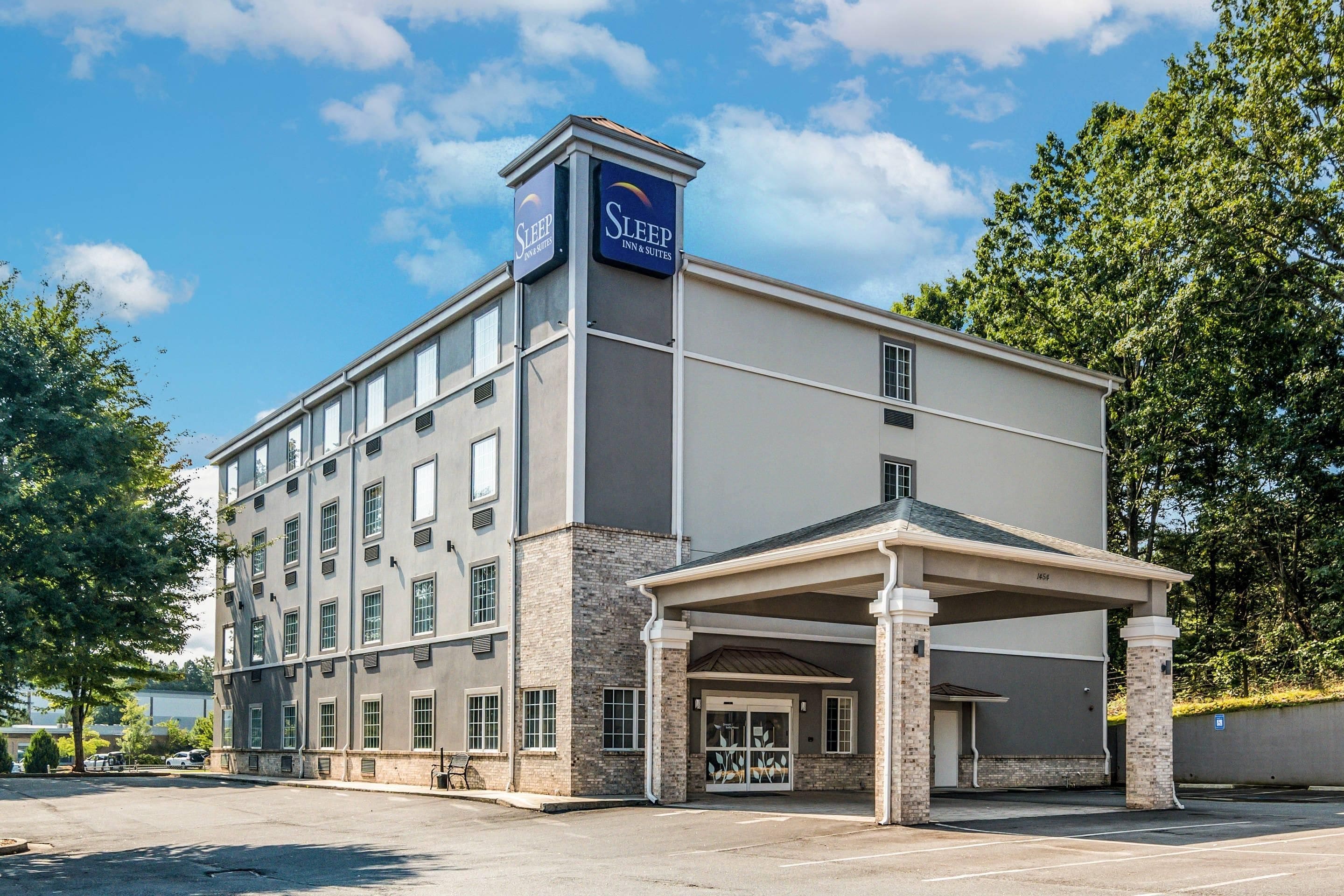 A Sleep Inn & Suites building with a covered entrance and a parking lot.