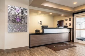 A hotel reception area with a desk, a computer, and a 'Sleep Inn & Suites' sign. - Sleep Inn and Suites at Kennesaw State University (Kennesaw)