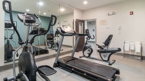 A gym with various exercise equipment, including treadmills and stationary bikes, and a large mirror reflecting the space. - Sleep Inn and Suites at Kennesaw State University (Kennesaw)