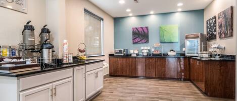 A modern kitchen with a central island, built-in appliances, and a large window.
