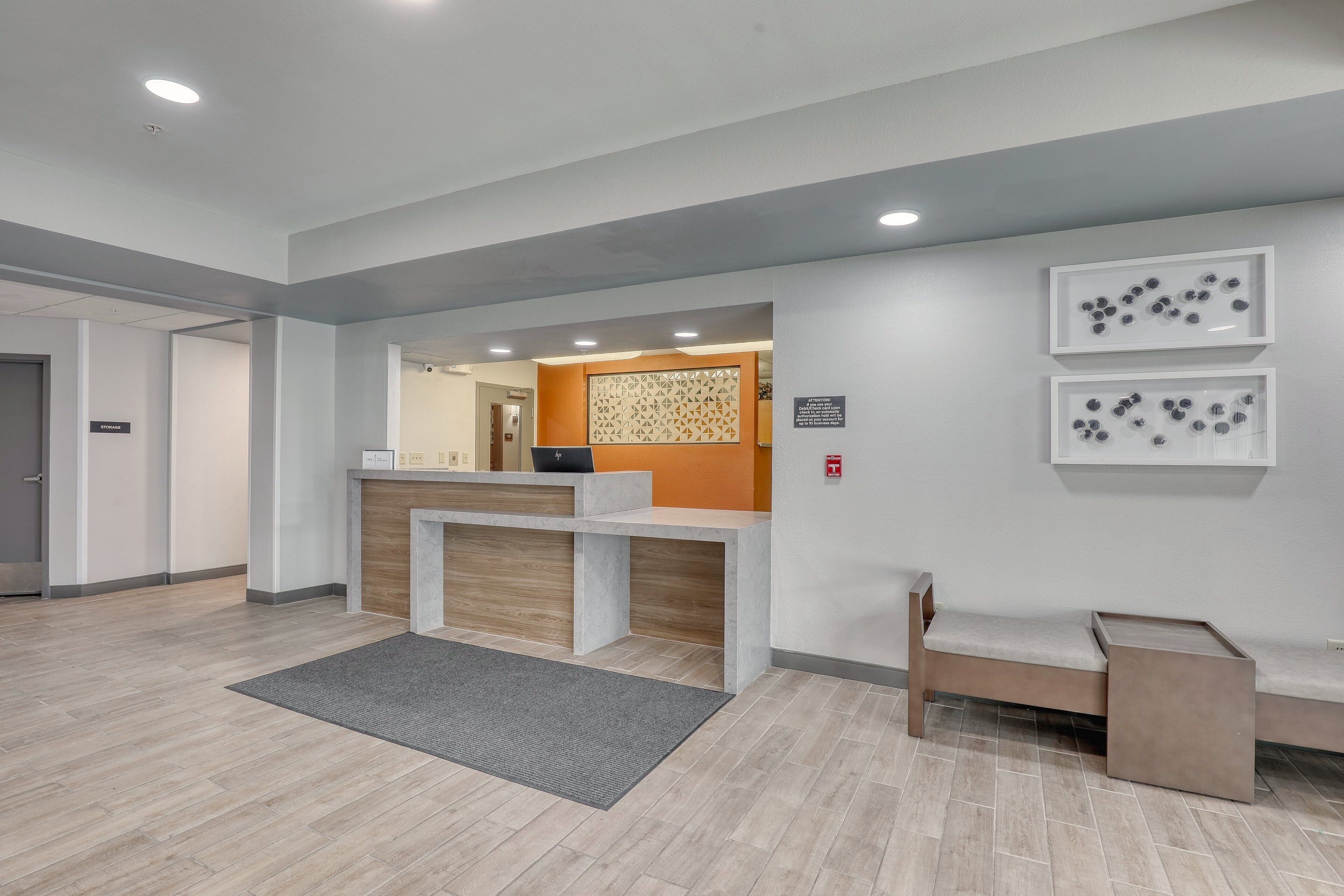 A reception area with a counter, a bench, and a patterned wall.