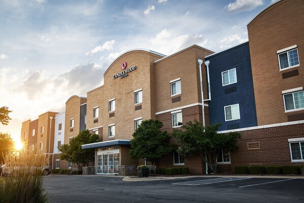 Um hotel com fachada de tijolos, várias janelas e uma placa com a inscrição "Candlewood Suites".