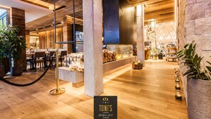 Un interior de restaurante con vigas de madera, una zona de bar y un área de mesas.
