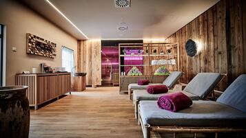 Relax in a serene spa room with a bathtub, towels, and comfortable reclining chairs.