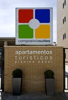 Segnaletica per 'compostelasuites' con logo e testo che indica 'appartamenti turistici, piscina, paddle'.