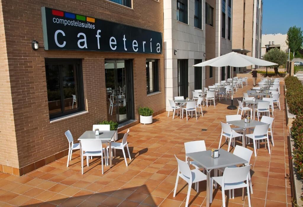 A cafe with outdoor seating, a sign reading "cafeteria," and a brick building facade.