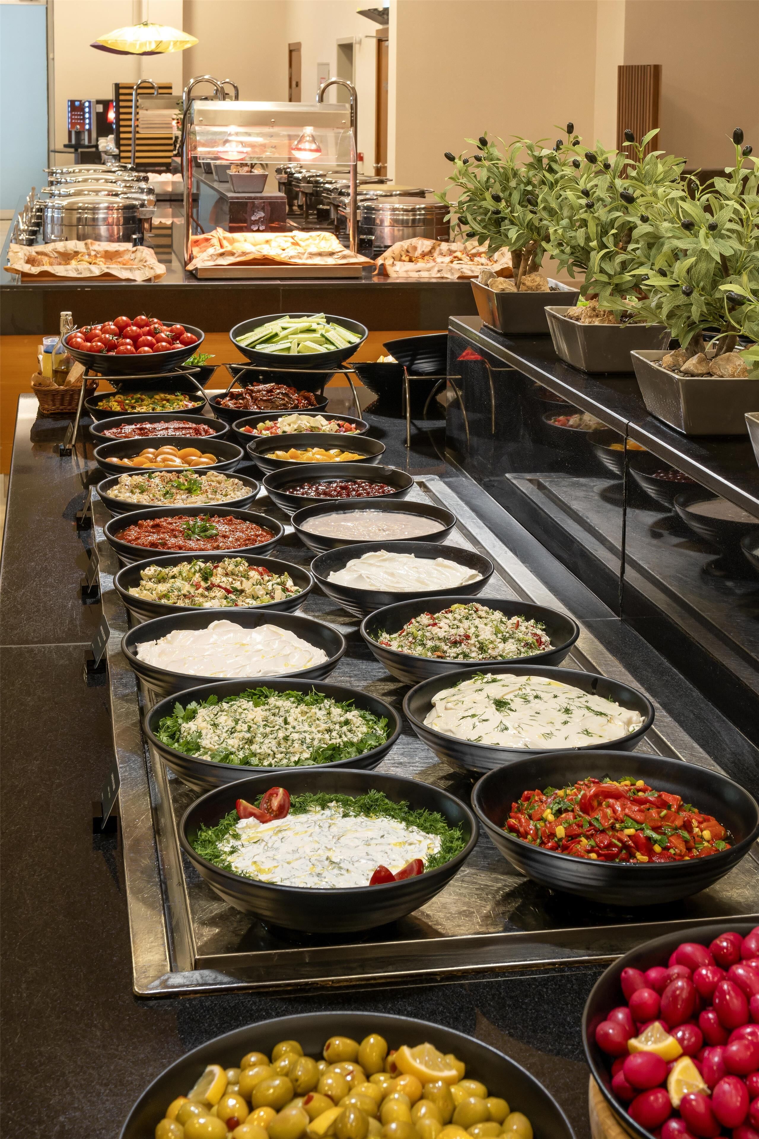 A buffet with various food items and a potted plant.