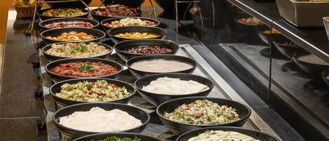 A buffet with various food items and a potted plant.