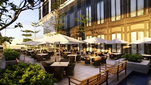 An outdoor café area with tables and chairs, umbrellas, and a pool. - Harbour Grand Hong Kong (Hong Kong)