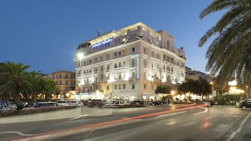 Un hôtel à plusieurs étages, doté d’une architecture classique, et dont le dernier étage est agrémenté d’une enseigne bien visible pour un restaurant.