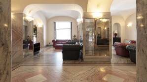 A spacious lobby with marble flooring, a large seating area with sofas, and a grand staircase. - Hotel Esplanade (Pescara)
