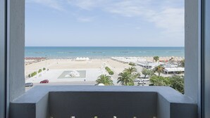 A beach view from a balcony with a clear sky, a sandy beach, and a few umbrellas. - Hotel Esplanade (Pescara)
