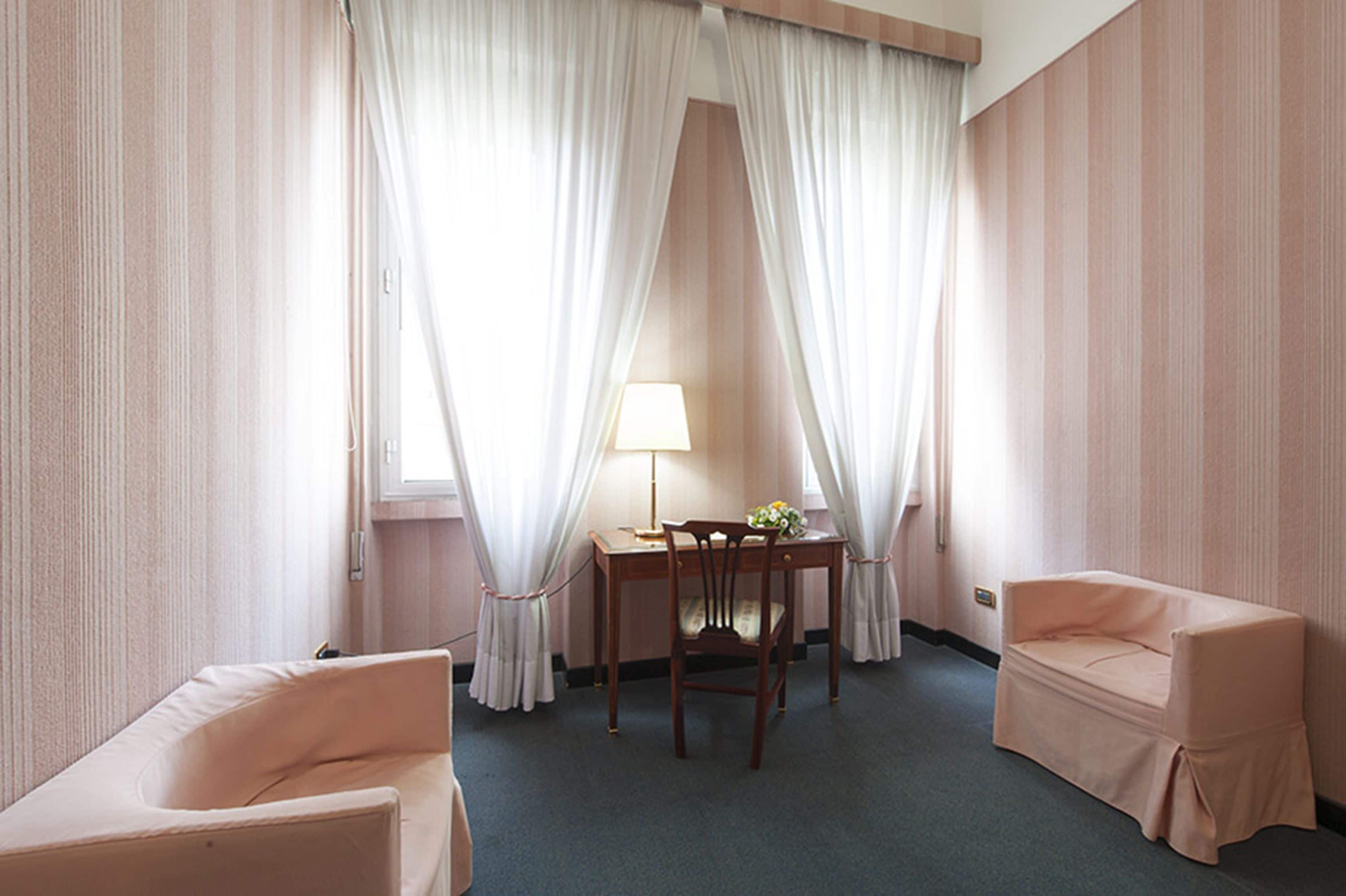 Une chambre d’hôtel avec un lit, un bureau, une chaise et un canapé.