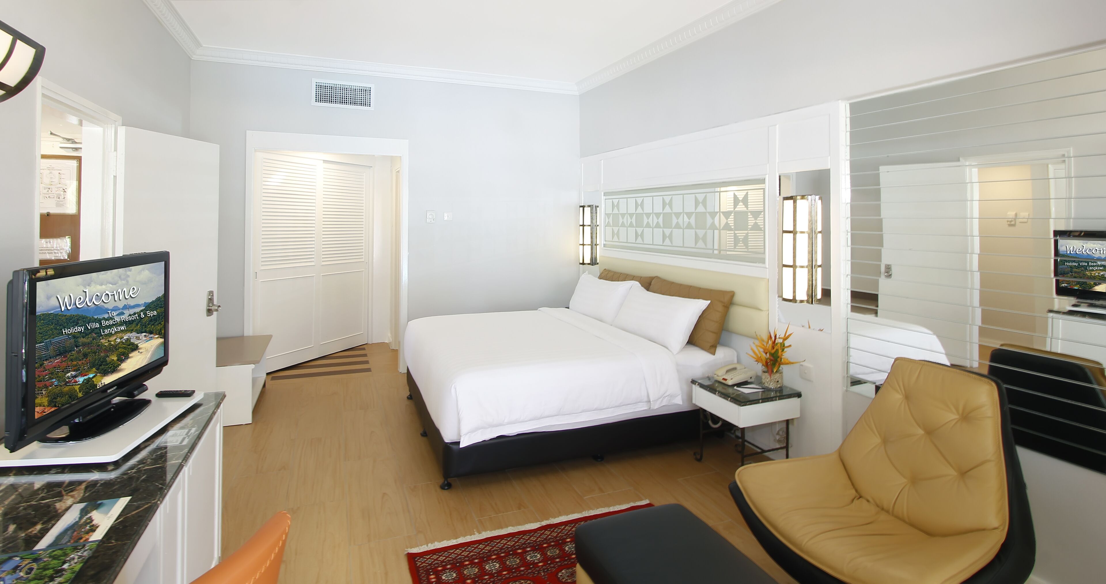 Une chambre d’hôtel équipée d’un lit, d’une télévision, d’un bureau, d’une chaise et d’une fenêtre avec des stores.