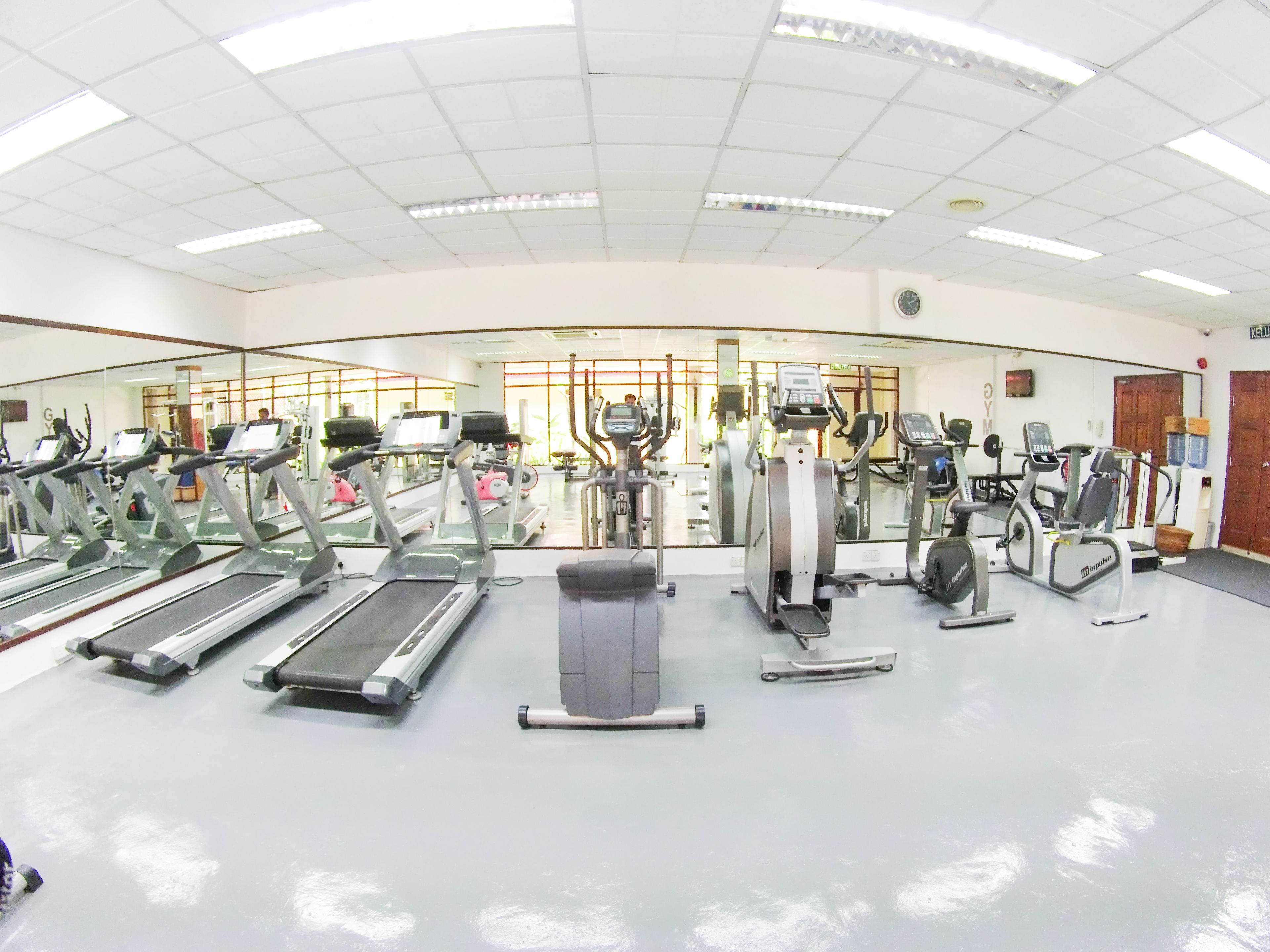 A gym with treadmills, elliptical machines, and weight equipment.
