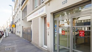 Un hôtel appelé « Séjours & Affaires », avec le numéro « 120 » sur la façade, un volet fermé sur le côté gauche et une entrée en verre sur le côté droit.