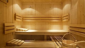 Eine Holzsauna mit Bänken und einem Holzeimer.