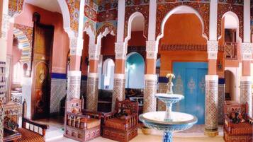 A traditional interior with arches, columns, and ornate furniture.