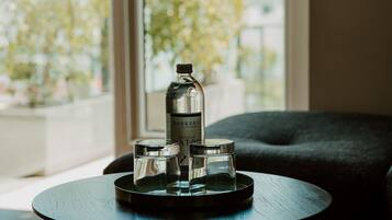 A round table with a bottle and two salt shakers on a tray.