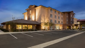 A multi-story hotel with a parking lot in front.