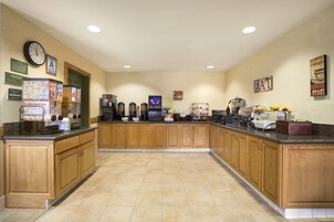 Una cocina amplia con armarios de madera, un espacio para café y diversos electrodomésticos.