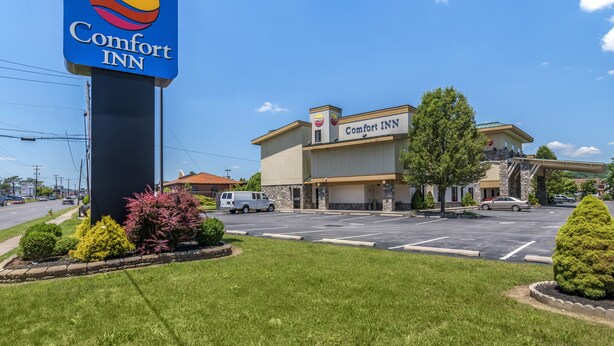 A Comfort Inn hotel with a parking lot, a large sign, and a building with a flat roof and a sign above the entrance.