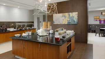 Une cuisine moderne dotée d’un îlot central, d’un espace buffet et d’un éclairage contemporain.