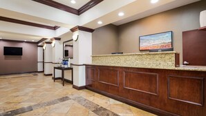 A hotel reception area with a reception desk, a flat-screen TV, and a tiled floor. - Best Western Coffeyville Central Business District Inn and Suites (Coffeyville)