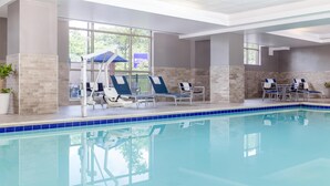 An indoor swimming pool with lounge chairs and a seating area. - Hilton Garden Inn Hanover Arundel Mills,  MD (Hanover)