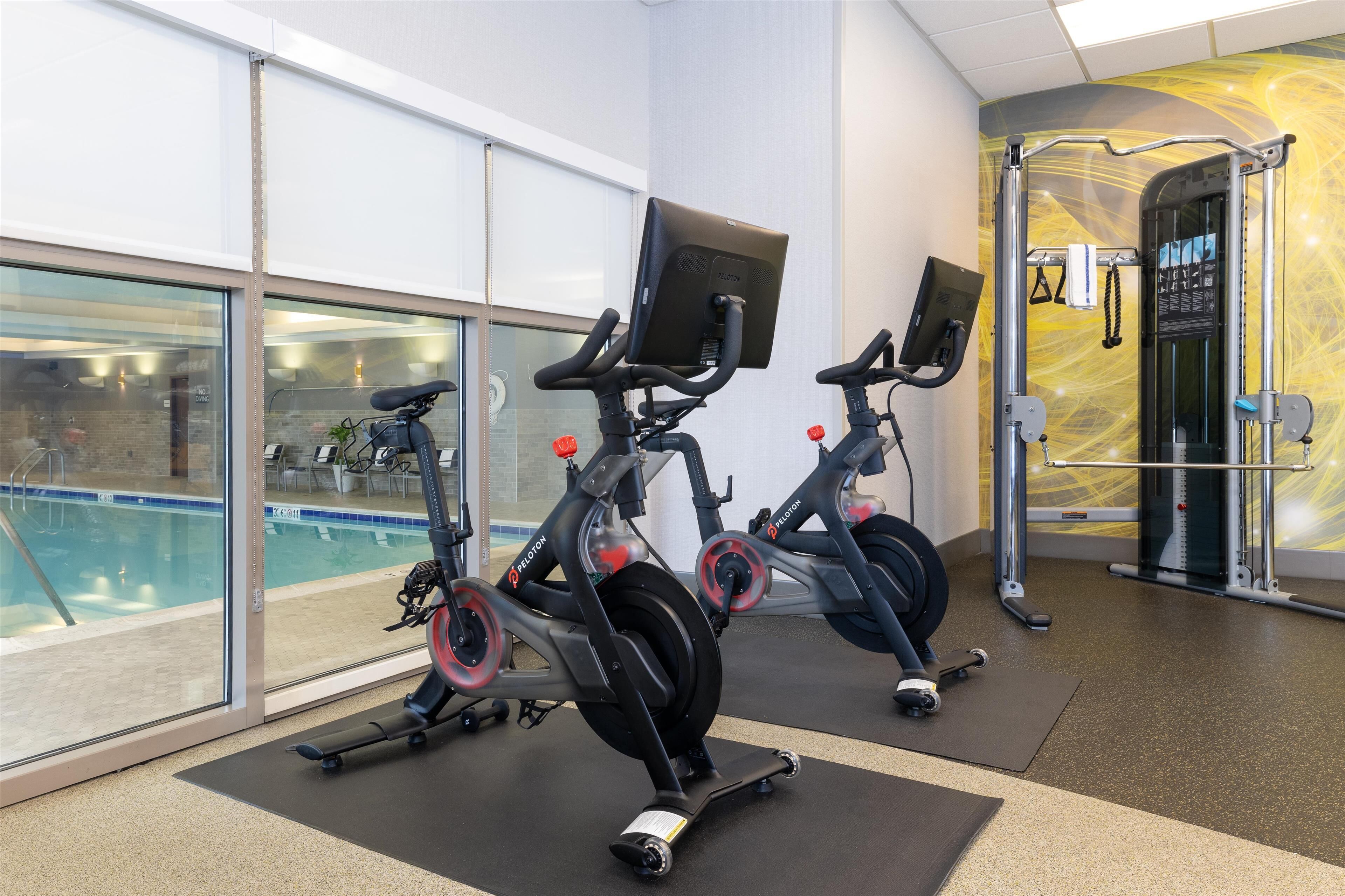 A gym with stationary bikes, a pull-up bar, and a weight machine.