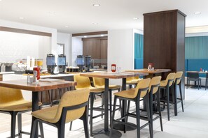 A modern dining area with multiple tables and chairs, a coffee station, and a kitchen in the background. - Hilton Garden Inn Hanover Arundel Mills,  MD (Hanover)